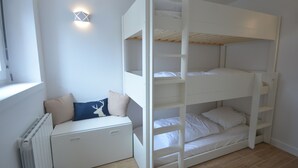 En våningssäng med en undre säng och ett förvaringsutrymme under.