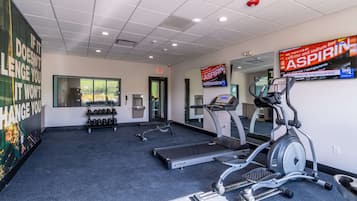 Un gimnasio con cintas de correr, elípticas y mancuernas.