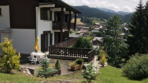 A building with a balcony overlooking a village and mountains. - Studio with terrace and garage in Les Gets (Les Gets)