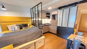 A compact bedroom with a bed, bedside tables, a desk, and a chair. - Modern Stylish Studio with Spa Access, Central Location, Close to Slopes (Les Gets)
