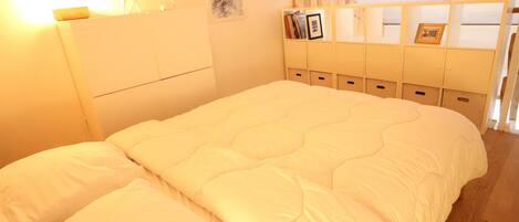 A bedroom with a large bed, wooden headboard, and built-in storage cabinets.