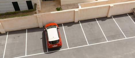 Vista aérea de un estacionamiento con un solo coche aparcado en un lugar asignado.