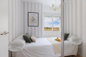 A bedroom with a bed, pillows, a framed picture on the wall, and a window with a view. - Fidalsa Bella Vista junto al mar (El Campello)