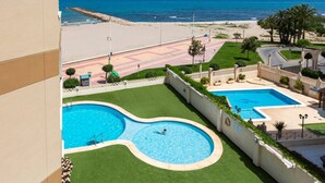 Un resort con zona de piscina, playa y vista al océano.