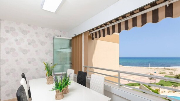 Un balcón con vista a la playa y al océano.