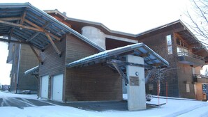 A building with a covered entrance, a concrete pillar with a plaque, and a snow-covered ground. - Ski-In/Ski-Out Apartment in Les Gets - 3 Stars, Balcony, Mountain Views, Free Shuttle (Les Gets)