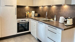 A modern kitchen with stainless steel appliances, a built-in oven, and a dishwasher.