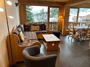 Un intérieur chaleureux en bois, avec un canapé, une petite table et une chaise.