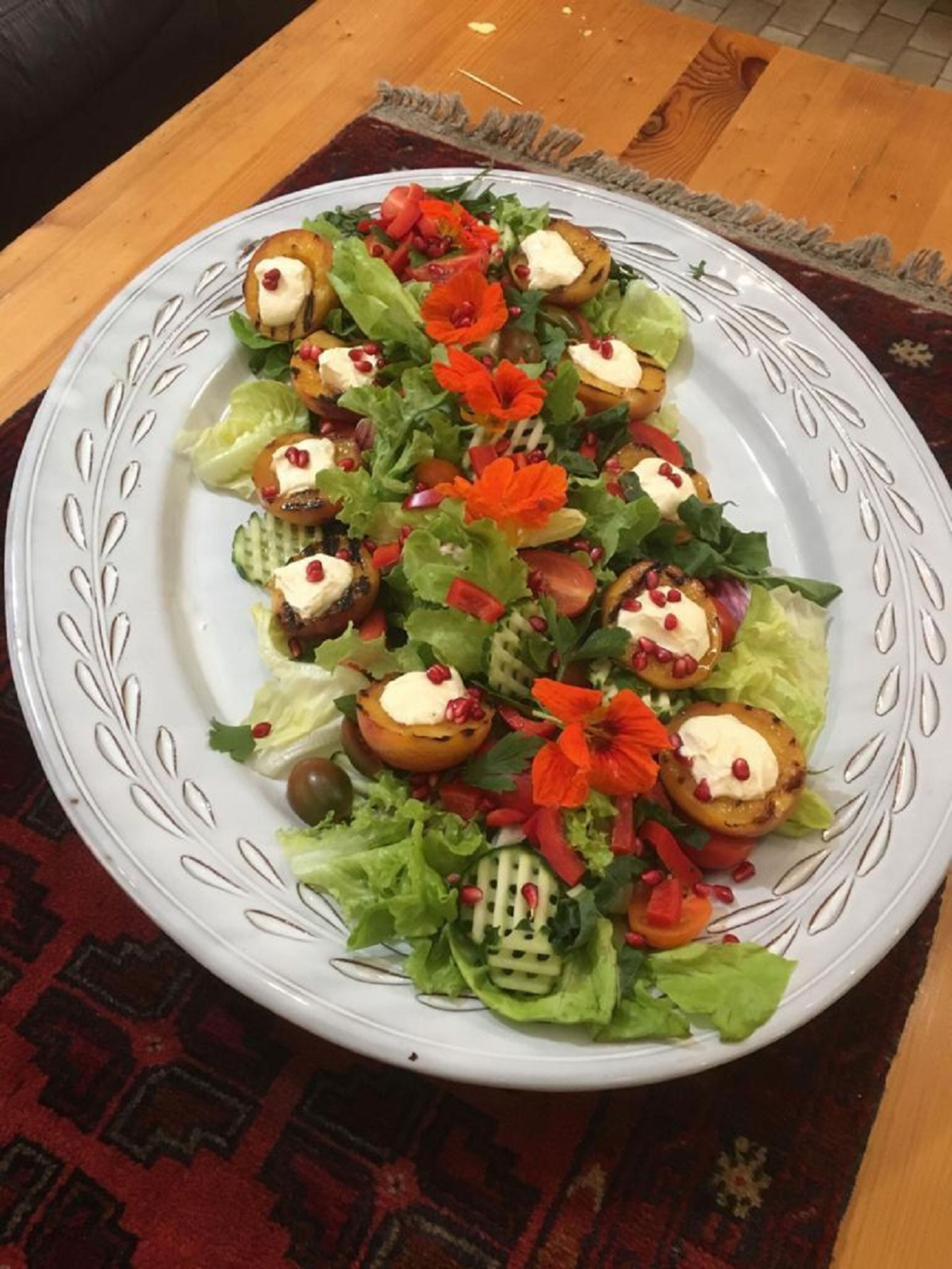 A plate of salad with various vegetables and a decorative plate.