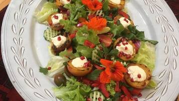 A plate of salad with various vegetables and a decorative plate.