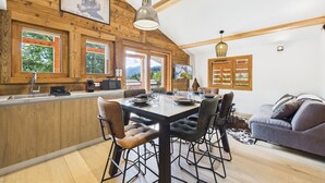 A cozy cabin interior with a wooden dining area, a bar, and a sofa. - Les Gets - Lovely apartment with balcony and fireplace near the slopes (Les Gets)