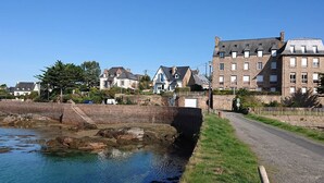 A coastal town with stone buildings, a clear blue sky, and a calm water body. - 1-bedroom apartment with WIFI, parking, pets allowed in Perros-Guirec (Perros-Guirec)