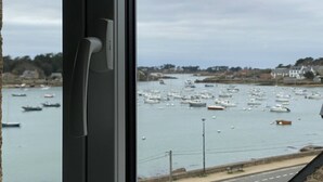 A view of a harbor with numerous boats, a stone wall, and a road with a bench. - 1-bedroom apartment with WIFI, parking, pets allowed in Perros-Guirec (Perros-Guirec)