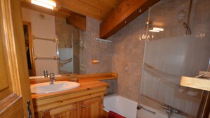 Une salle de bain en bois avec un lavabo, un miroir et une baignoire.