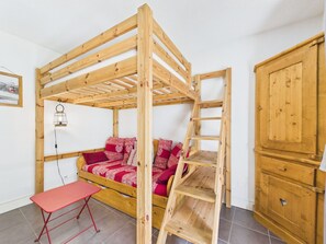 A wooden bunk bed with a ladder, a red bench, and a cabinet. - Central Les Gets Apartment with Terrace, Garage and WIFI (Les Gets)