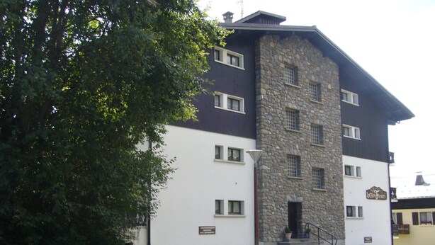 A two-story building with a stone facade and a white lower section.