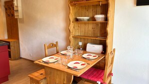 A wooden dining table set with plates, glasses, and cutlery.