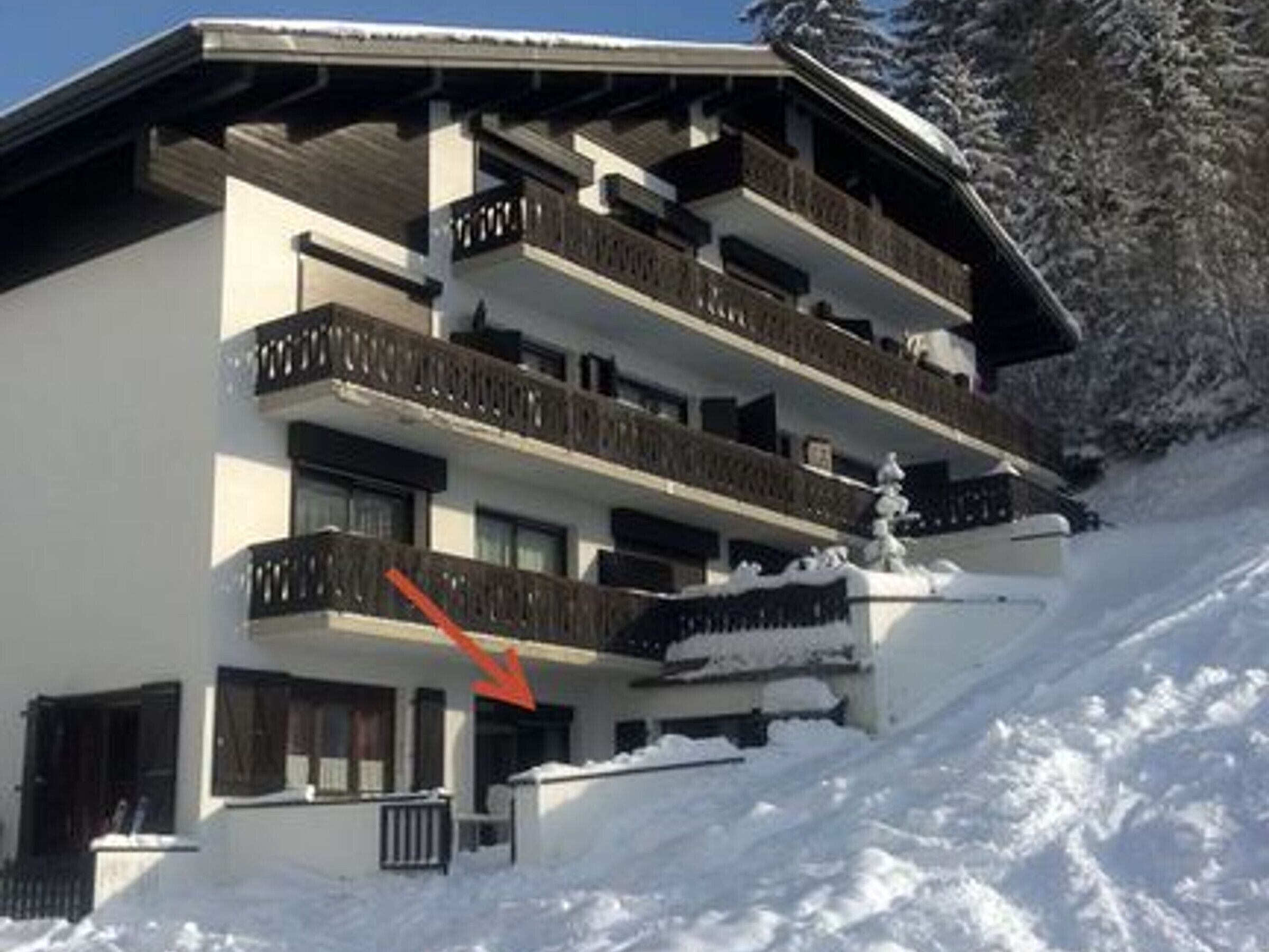 A multi-story building with balconies, surrounded by snow.