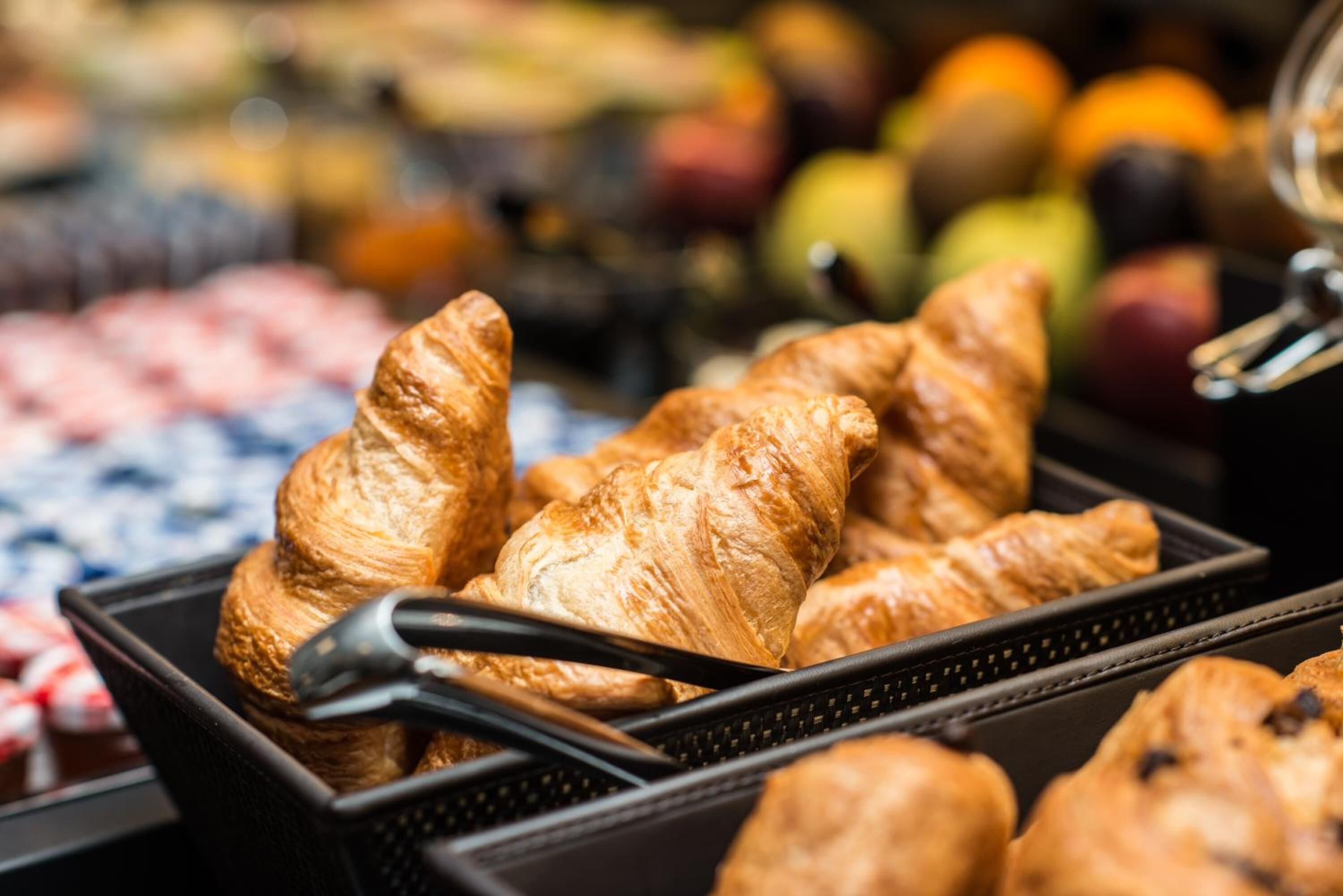 Una bandeja de cruasanes en una vitrina de panadería.