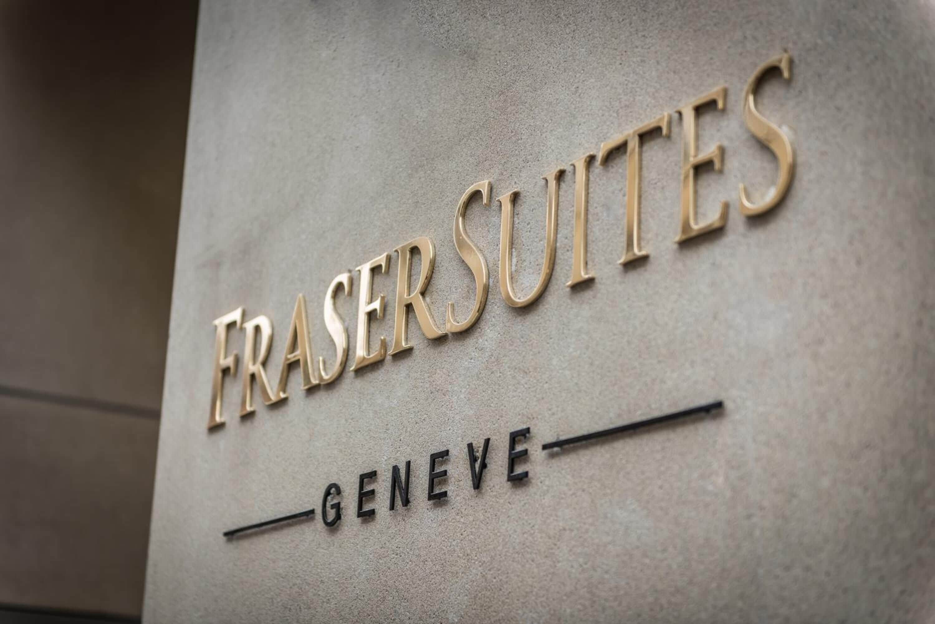 A sign with the words "FRASER SUITES" and "GENEVE" indicating the name of a hotel or property.