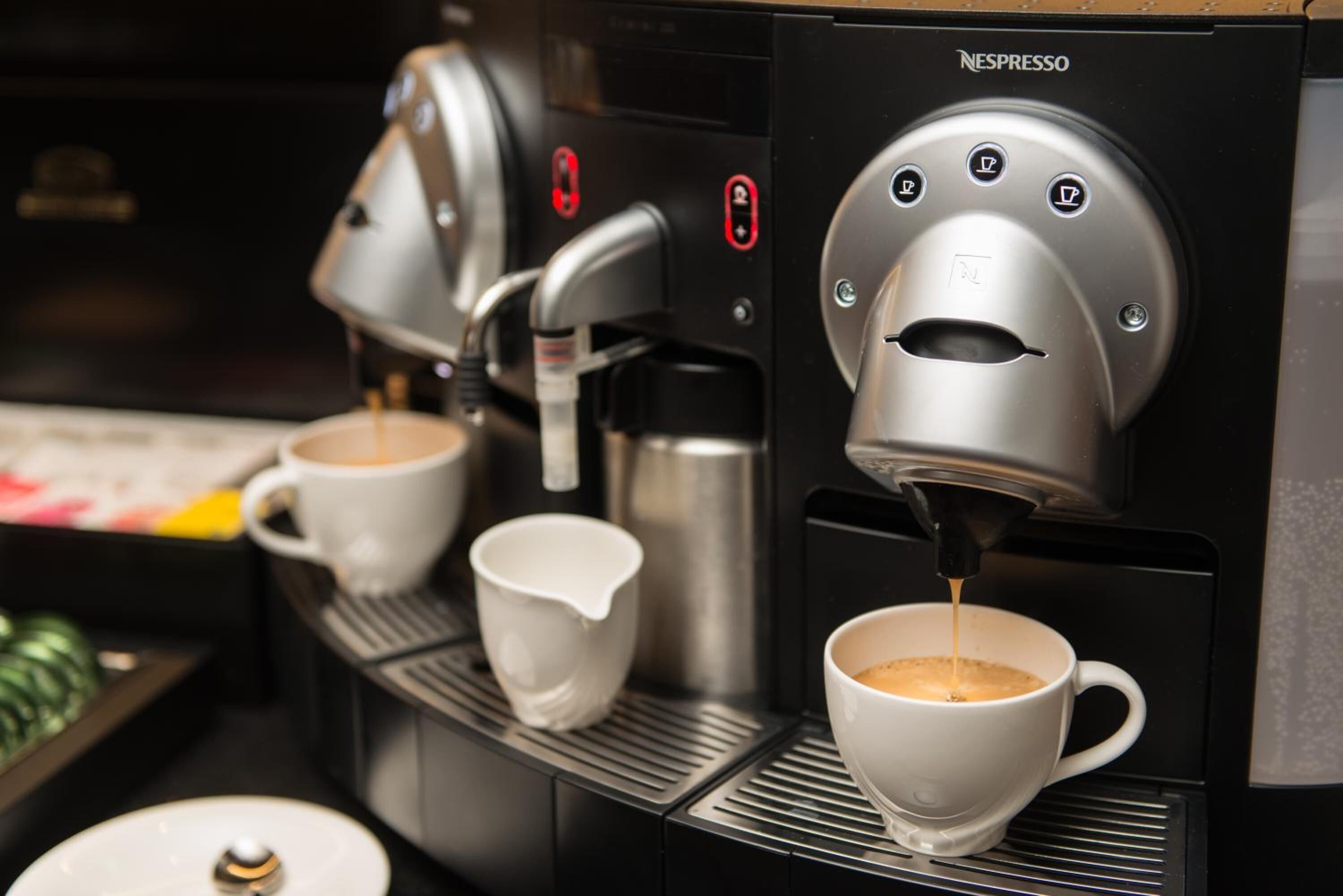 Una màquina de Nespresso servint cafè a una tassa.