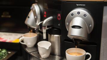 Una màquina de Nespresso servint cafè a una tassa.