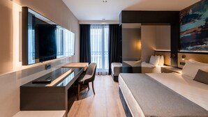 A modern hotel room with a large bed, a desk, a chair, and a television. - Ni Hotel Lara (Antalya)