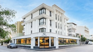 A modern hotel with a white facade, large windows, and a prominent entrance. - Ni Hotel Lara (Antalya)