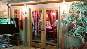 A room with a television, a wooden cabinet, a dining table with red curtains, and a potted plant. - Top location, no cleaning fee, everthings close B (Lake Geneva)