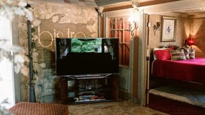 A cozy living room with a flat-screen TV, a fireplace, and a red bed. - Top location, no cleaning fee, everthings close B (Lake Geneva)