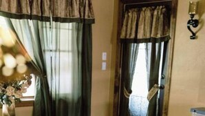 A room with a bed, a small table, a lamp, and a window with curtains. - Top location, no cleaning fee, everthings close G (Lake Geneva)