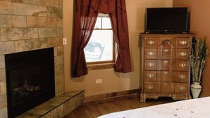 A room with a fireplace, a wooden dresser, a television, and a window with curtains. - Top location, no cleaning fee, everthings close G (Lake Geneva)