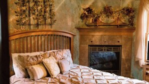 Une chambre à coucher avec un lit, une cheminée et un élément décoratif mural.