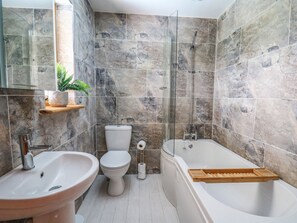 A bathroom with a sink, toilet, and bathtub, all with marble walls and a wooden shelf. - The Larches (Llanidloes)