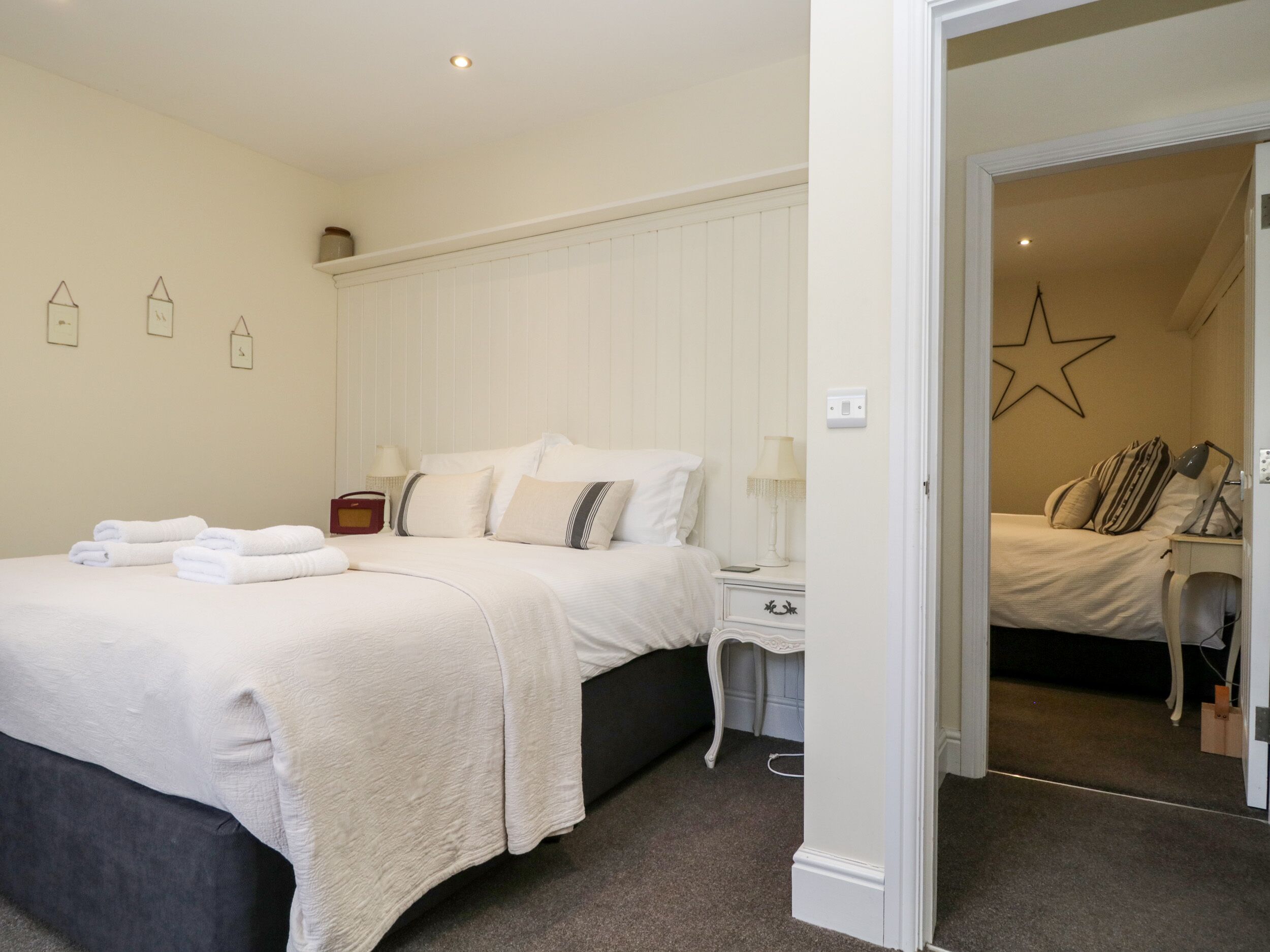 A bedroom with a bed, bedside tables, lamps, and a star decoration on the wall.