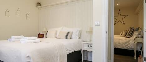 A bedroom with a bed, bedside tables, lamps, and a star decoration on the wall.