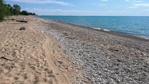 Una playa pedregosa con cielo despejado y mar tranquilo.