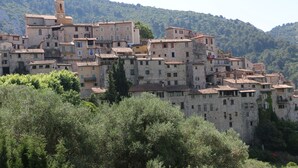 A historic village with stone buildings, a prominent tower, and lush greenery. - "Mas Thomasine <br>quiet romantic apartment in nature in Peillon (Peillon)