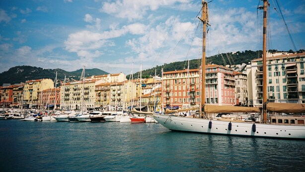 A marina with multiple boats docked, surrounded by colorful buildings with balconies, under a clear sky. - "Mas Thomasine <br>quiet romantic apartment in nature in Peillon (Peillon)