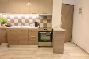 Eine moderne Küche mit Holzausstattung, einem eingebauten Backofen und einer karierten Spritzschutzwand.