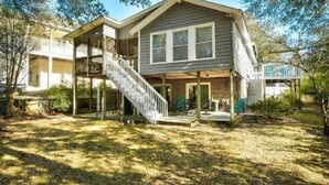 A two-story house with a covered porch and a staircase leading to the upper level.