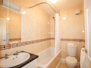 Une salle de bain avec une baignoire, des toilettes et un lavabo.