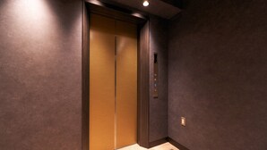 A modern elevator with a metallic interior and a control panel with accessibility features. - Rakuten STAY Tokyo Asakusa (Tokyo)