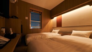 A hotel room with two beds, a window, a bedside table with a phone and tissues, and a wall-mounted light fixture. - Rakuten STAY Tokyo Asakusa (Tokyo)