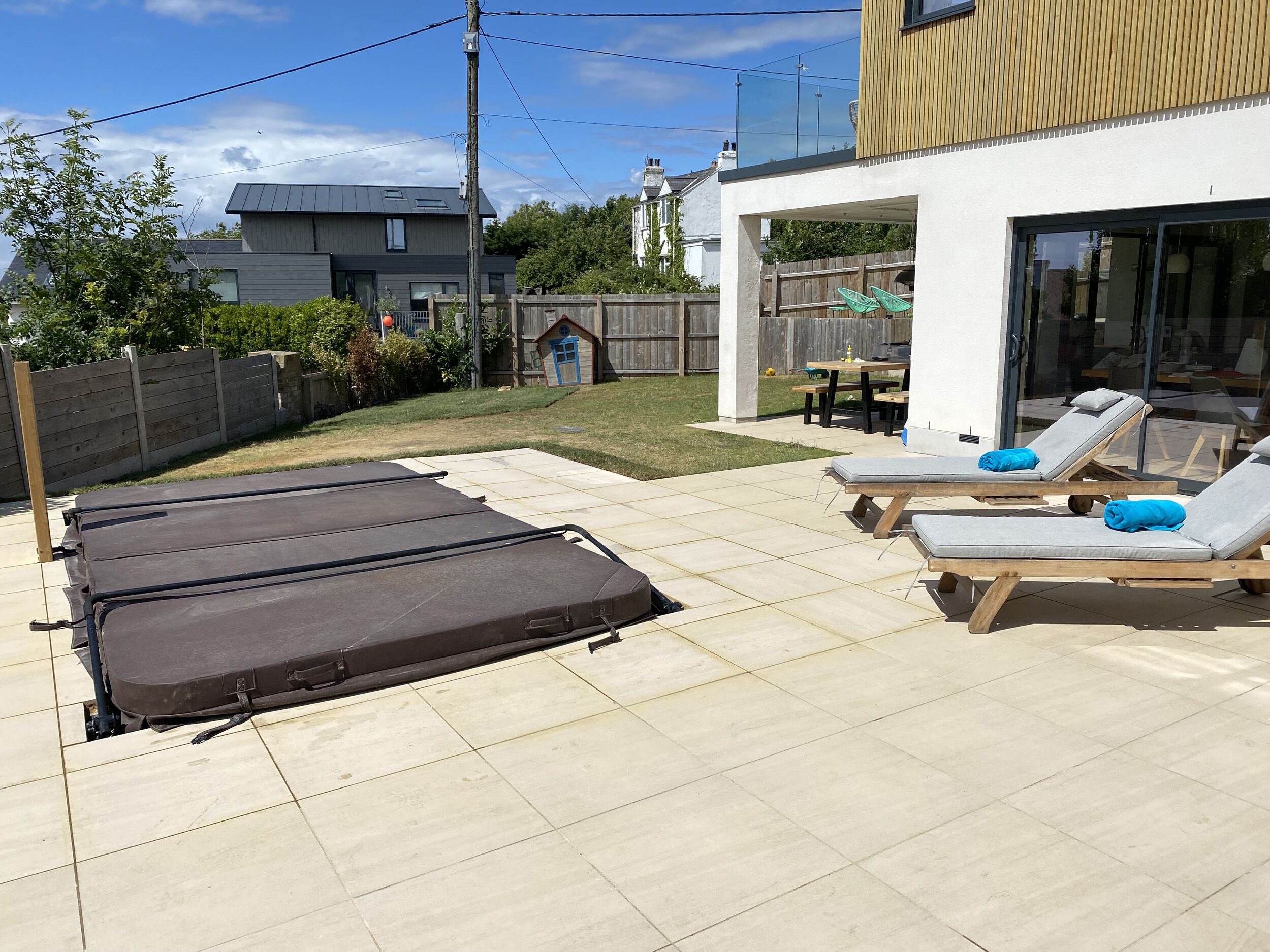 A patio with sun loungers and a trampoline.
