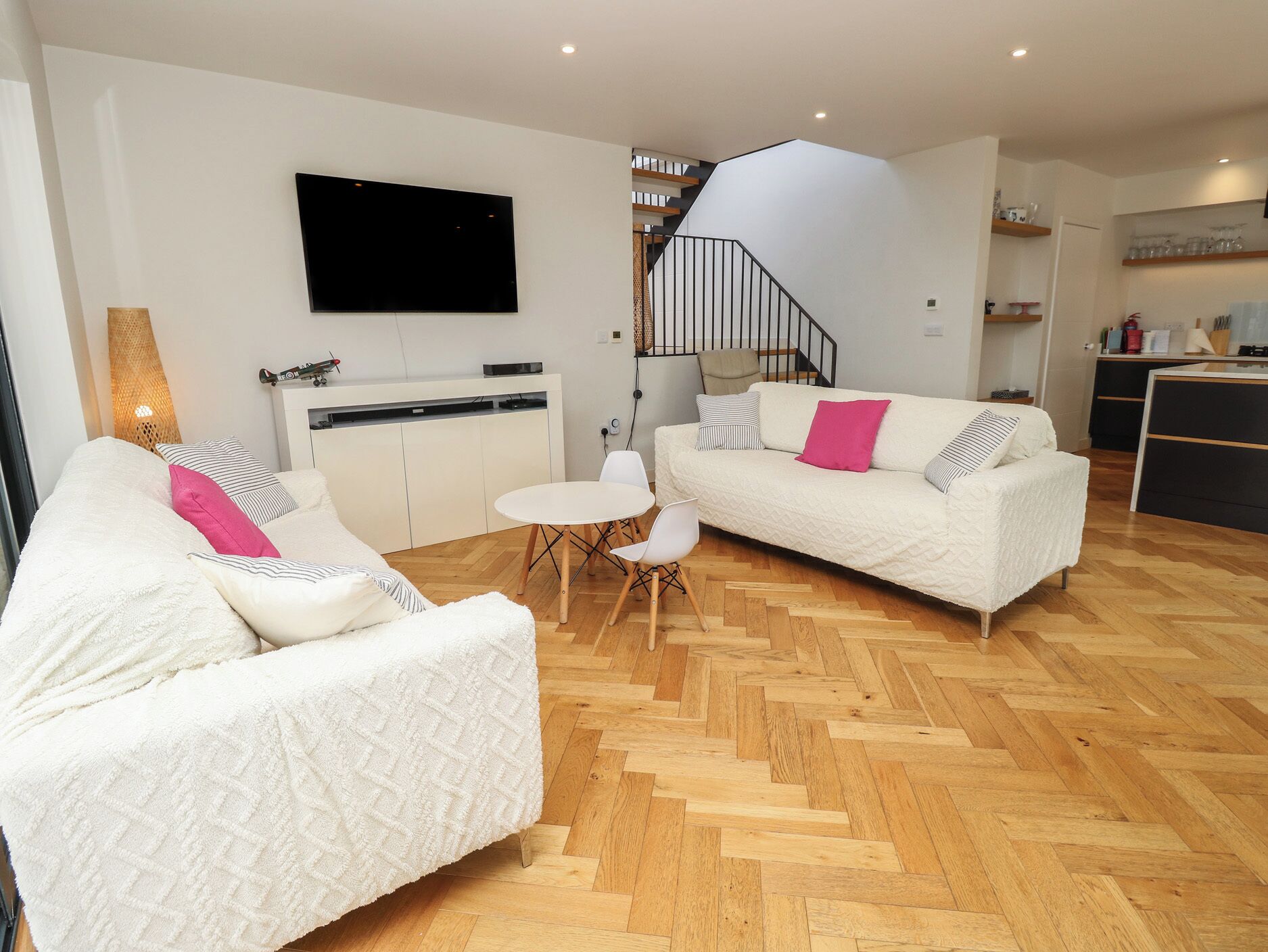 A modern living room with a sofa, a coffee table, and a TV mounted on the wall.
