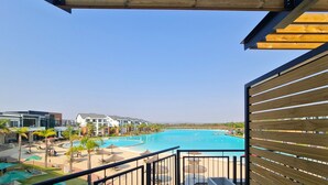A resort with a large swimming pool, multiple buildings, and a clear sky. - MINT Resorts the Blyde (Pretoria)