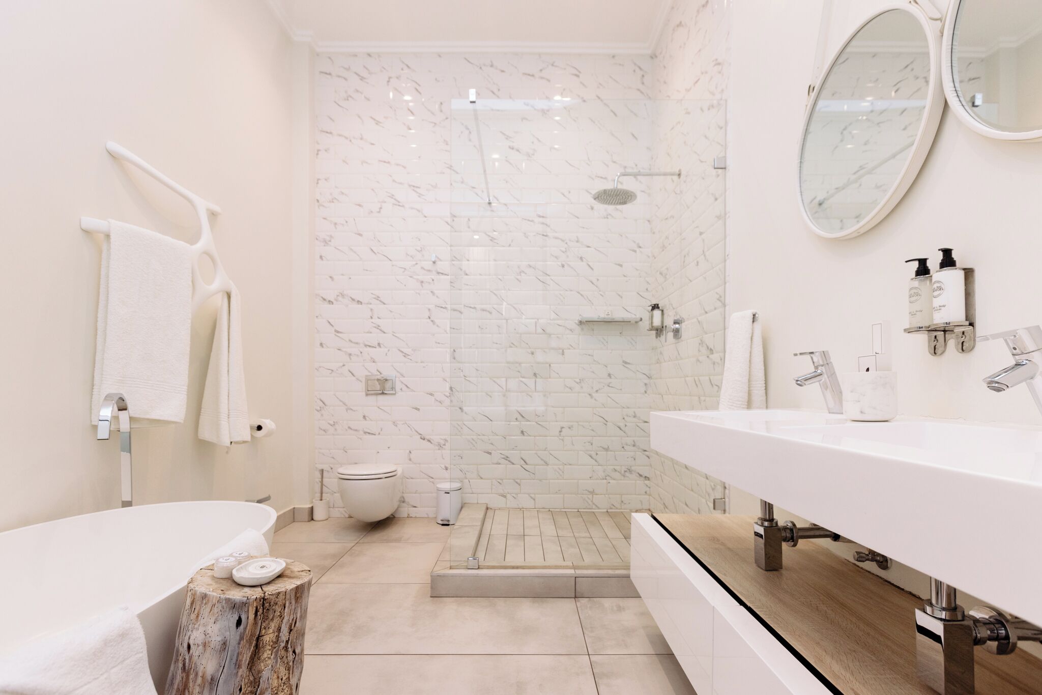 Une salle de bain moderne avec une baignoire sur pieds, un espace douche et un meuble-lavabo avec un miroir.