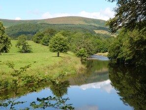 A serene landscape with a river, lush greenery, and hills in the background. - Low Orchard House (Preston)