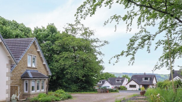 Un quartier résidentiel avec des maisons, une allée gravillonnée et de la verdure environnante.